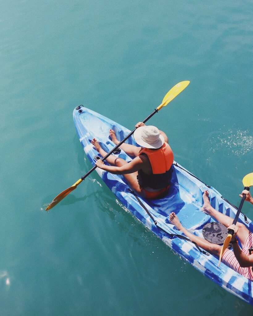Couple paddles in double kayak on lagoon